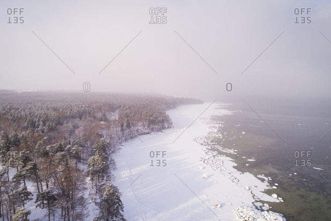 Aerial view of the snowy misty coast of Muraste, Estonia