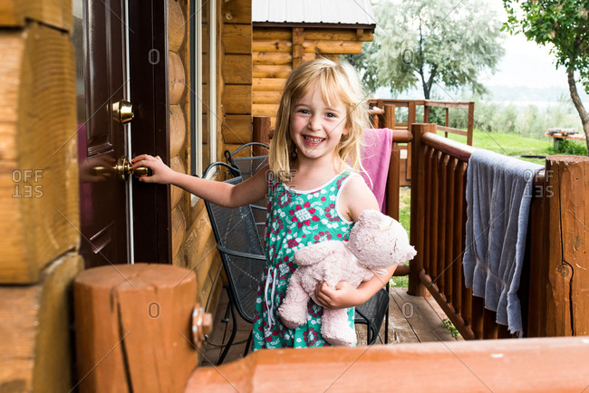 Happy little girl opening door to cabin