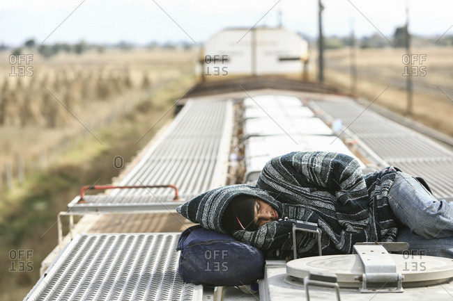 Mexico - November 07, 2007: Young migrant sleeping on roof of train hoping to cross border into United States of America