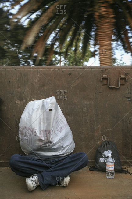 Mexico - November 07, 2007: Young migrant sitting in train wagon covered in sack hoping to cross border into United States of America