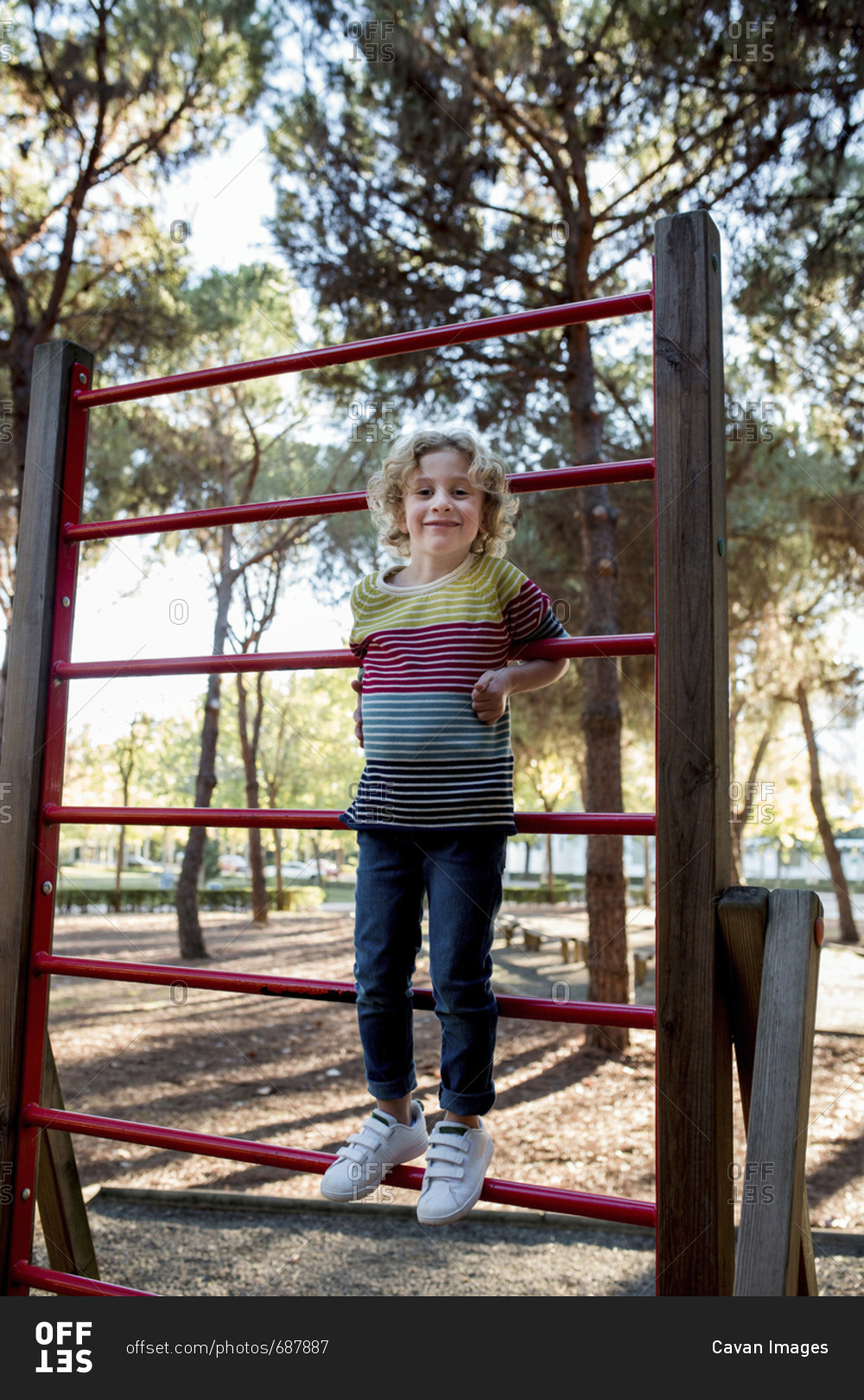 Portrait of girl standing on outdoor play equipment at park