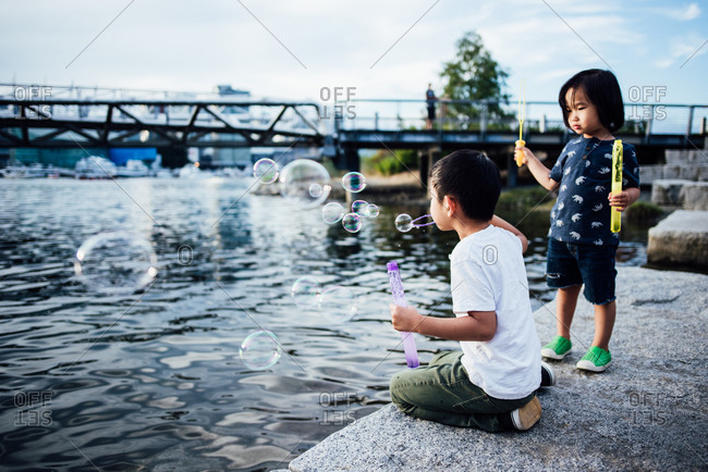 Boy blowing bubbles outside