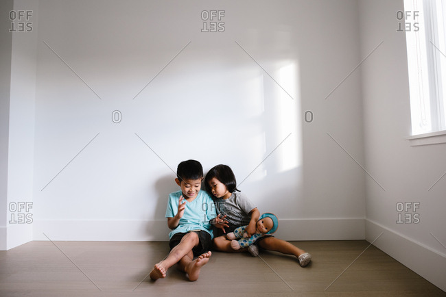 Kids sitting on floor playing on a device