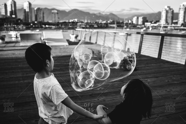 Boys blowing bubbles outside