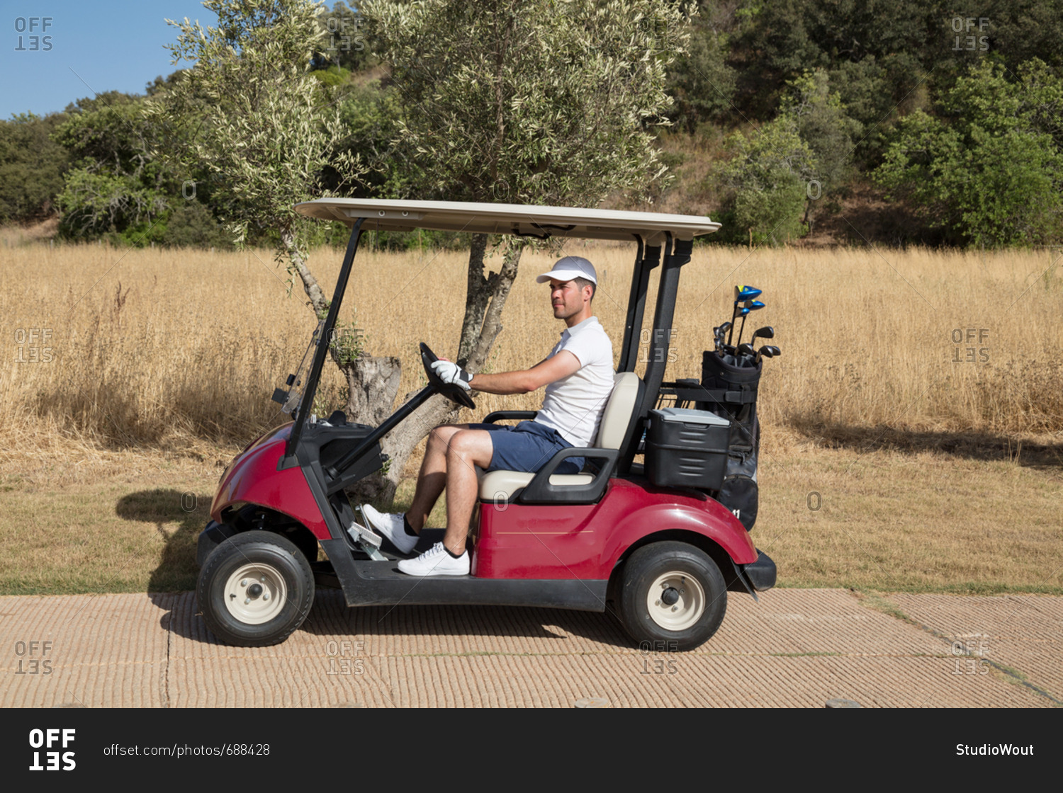 Man driving golf cart in nature