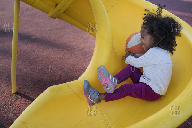 Little Girl Sliding Down Playground Slide Stock Photo, Picture and