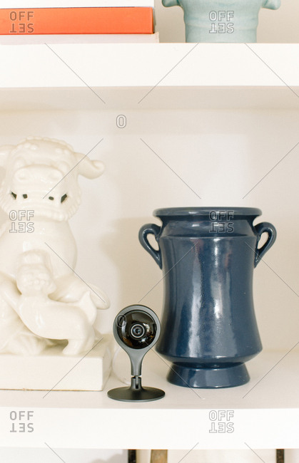 Webcam prominently on display next to ornaments on shelf in home