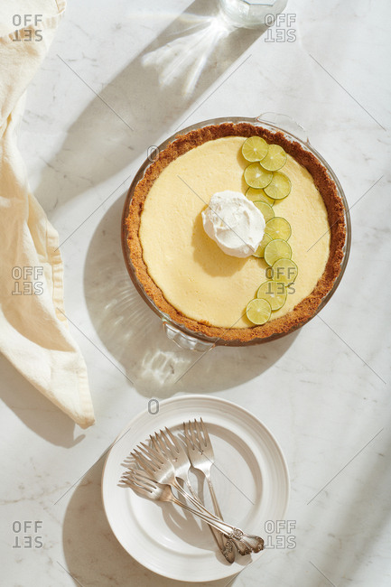 Overhead view of Key Lime Pie with sugared key lime slices and dollop of whipped cream