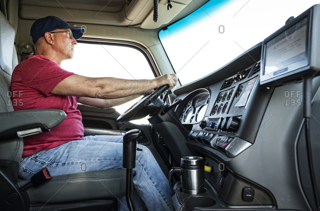 Caucasian man truck driver in the cab of his commercial truck