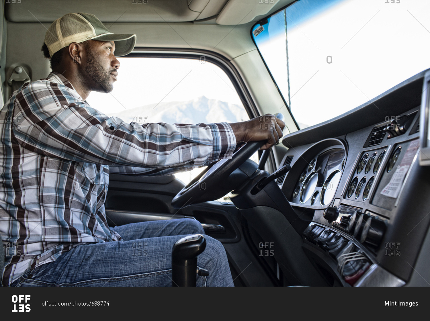 Black man truck driver in the cab of his commercial truck