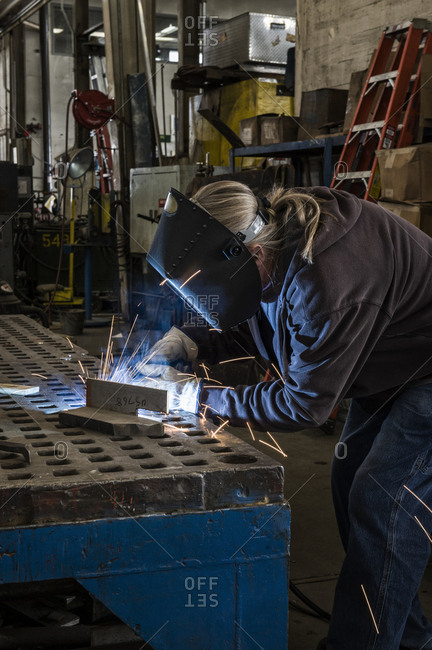 Factory worker using Oxyacetylene gas to weld two piece of metal in a sheet metal factory