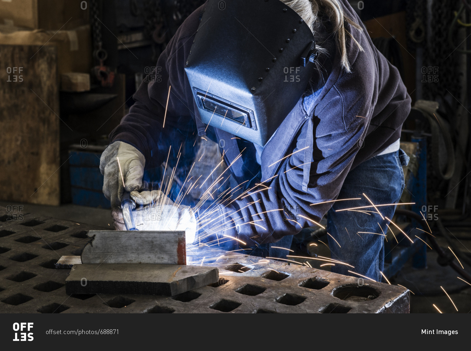 Factory worker using Oxyacetylene gas to weld two piece of metal in a sheet metal factory