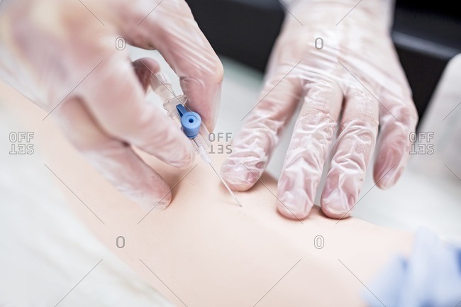 Doctor practicing inserting an IV line