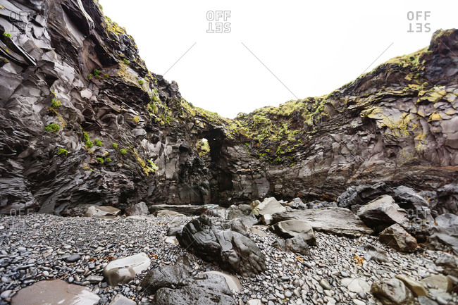 Rock arch providing access to sea beyond in Hellnar, Iceland