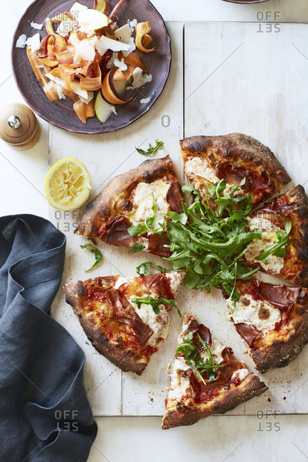 Precut slices of prosciutto pizza from above