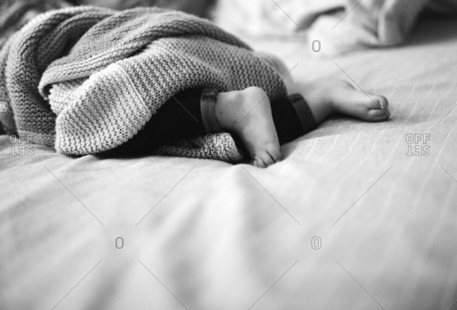 Closeup of sleeping infant's feet under blanket