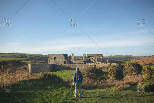 Rear view of male hiker standing with backpack at countryside