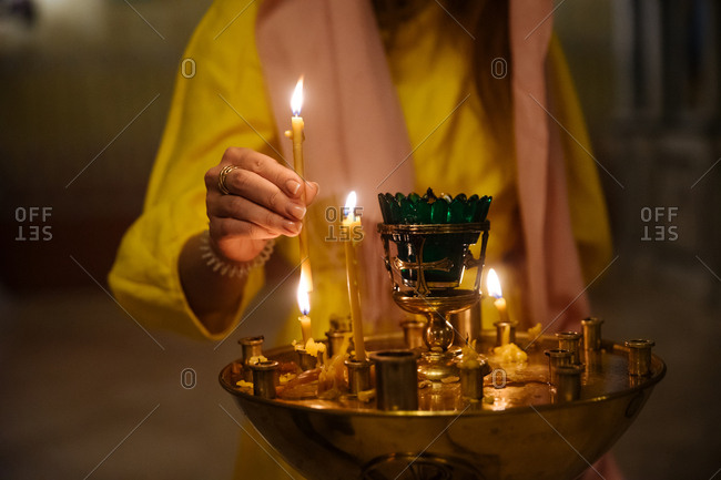Close up of woman lighting votive candle in church