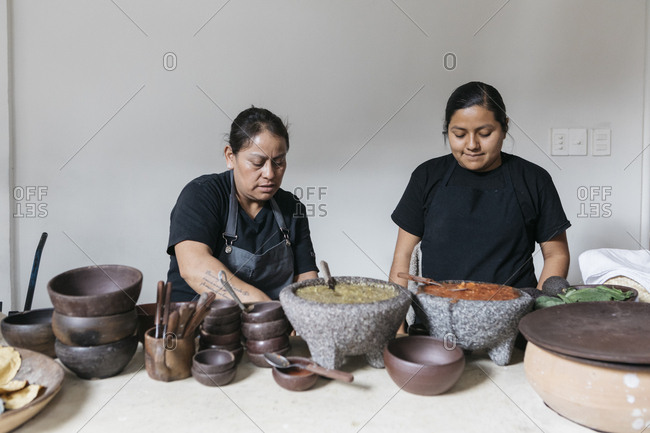 Oaxaca City, Mexico - January 25, 2018: Female restaurant cooks making large batches of fresh salsa