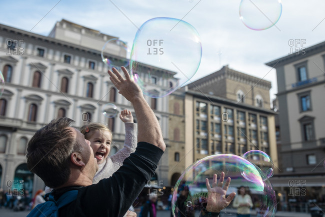 FLORENCE, ITALY - OCTOBER 31: Children react to a busker producing bubbles in the Piazza della Republica