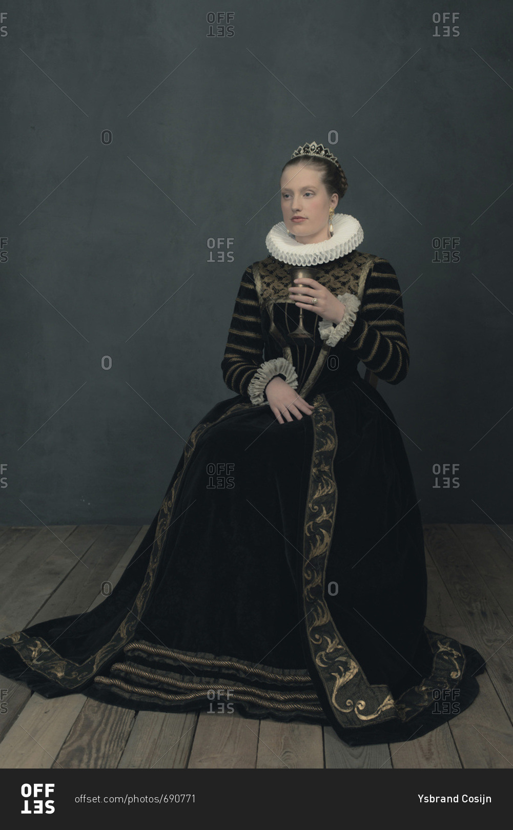 Historic duchess in black dress and white ruff sitting with goblet.