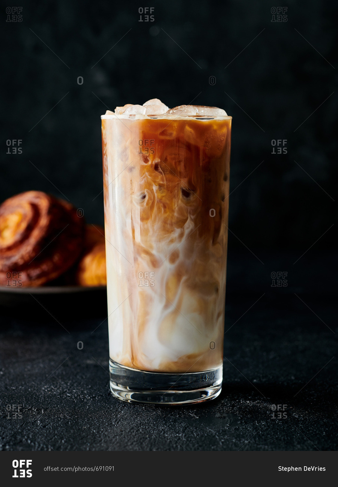 Ice coffee served in glass with milk swirling around