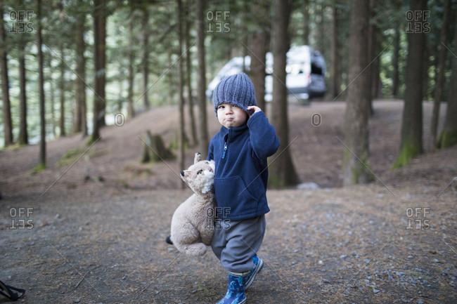 Boy holding teddy bear in forest, Harrison Hot Springs, British Columbia, Canada