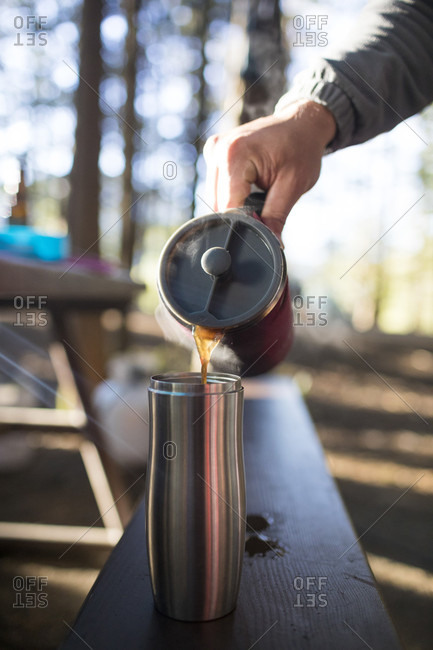 Person pouring coffee at picnic table, Harrison Hot Springs, British Columbia, Canada