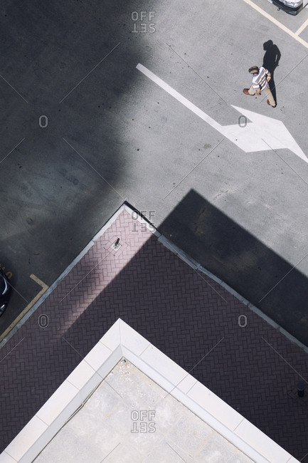 Man walking in parking lot seen from above in Jumeirah Lake Towers, Dubai