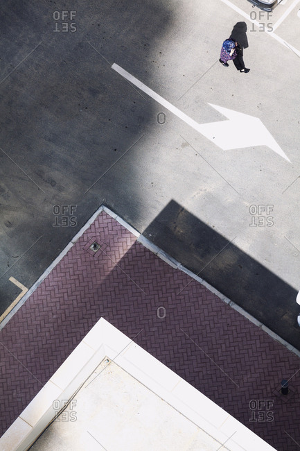 Woman walking in parking lot seen from above in Jumeirah Lake Towers, Dubai