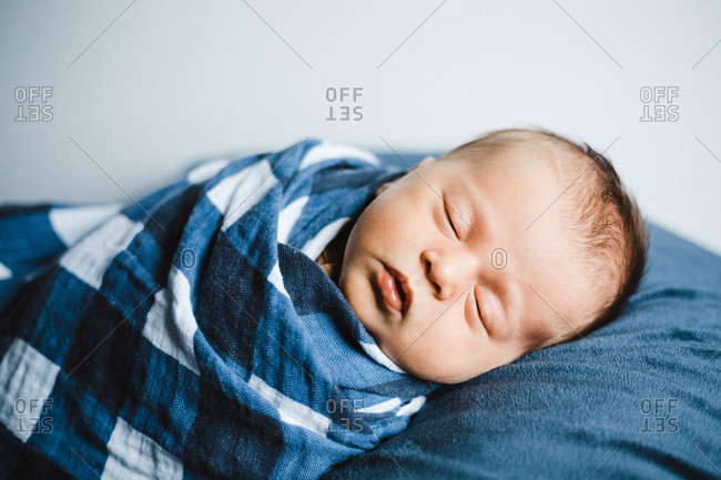 Newborn baby boy sleeping on a blanket stock photo - OFFSET