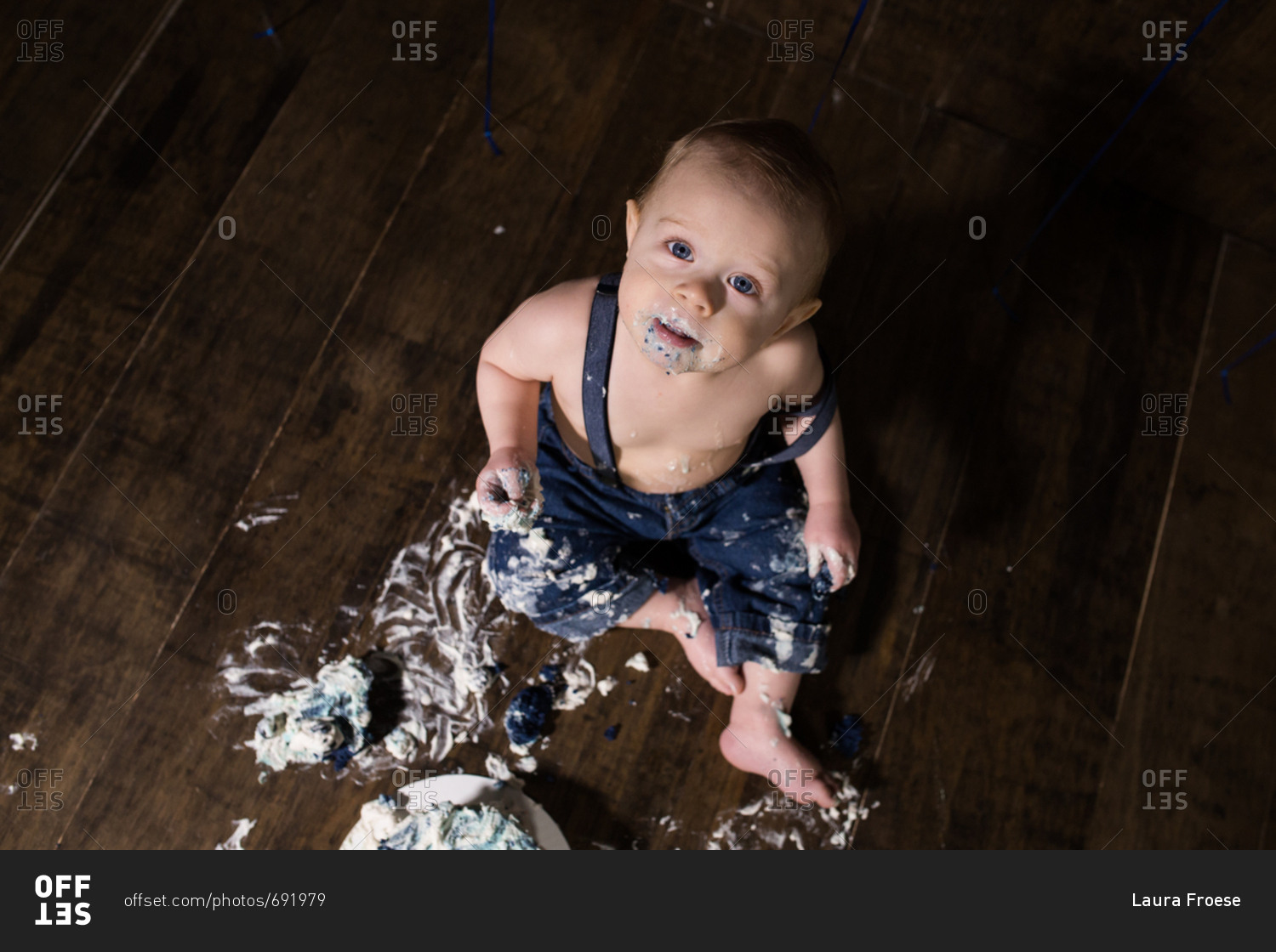 Baby boy covered in mess from birthday smash cake