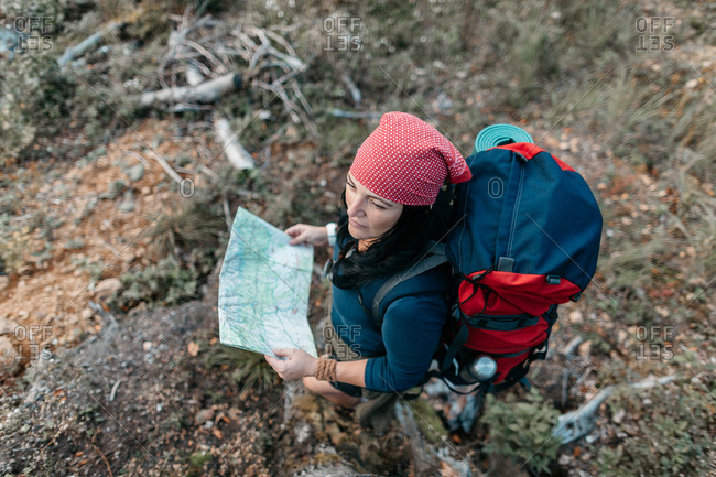 Beautiful woman hiker posing with a map