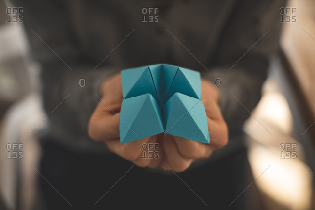 Close-up of women showing origami at home