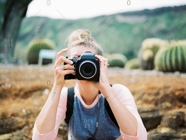 Portrait of woman with camera covering her face