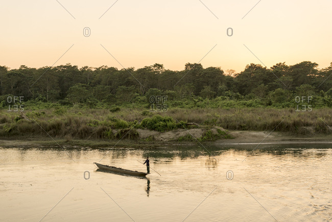 Nepal - June 6, 2012: Man on a canoe in a river at Chitwan National Park, Nepal