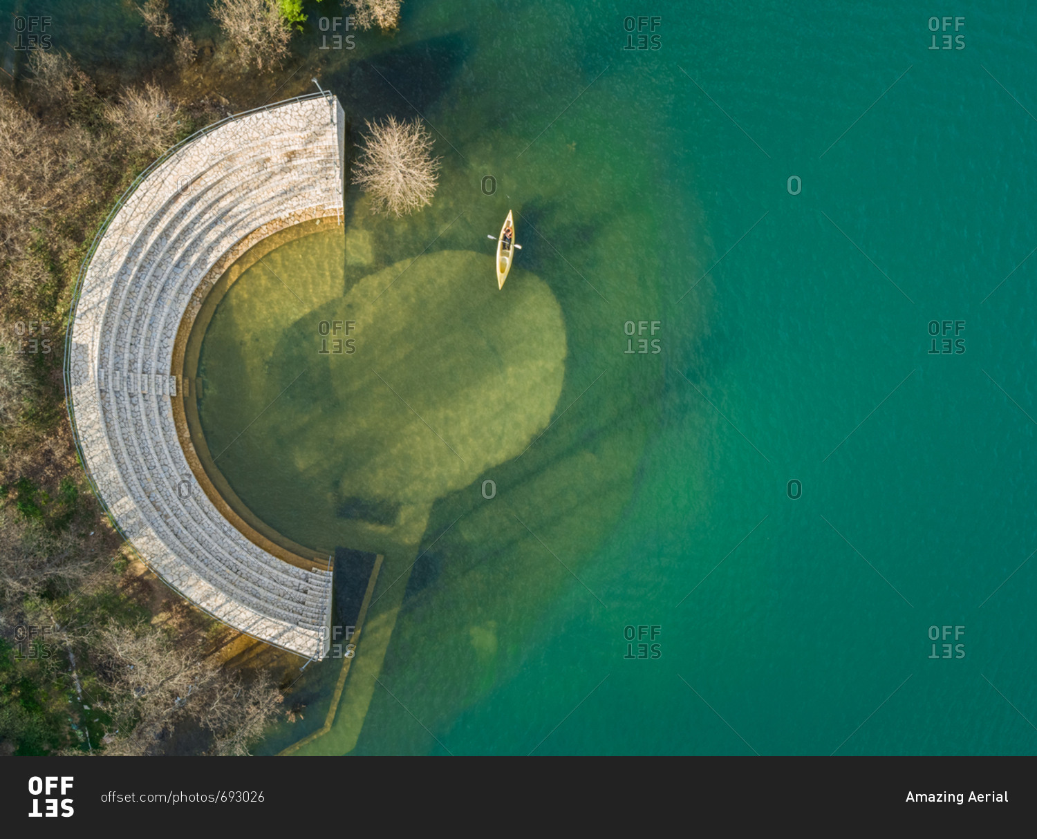 Aerial view of person kayaking next to old amphitheater at beautiful lake Plastira in Greece