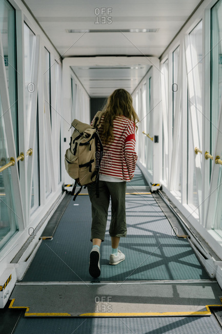 Rear view of woman walking in jet bridge