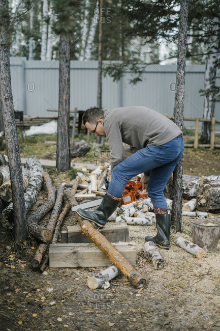 Man using chainsaw to cut firewood