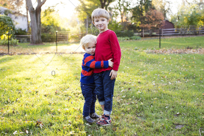 Portrait of two loving brothers outside at sunset