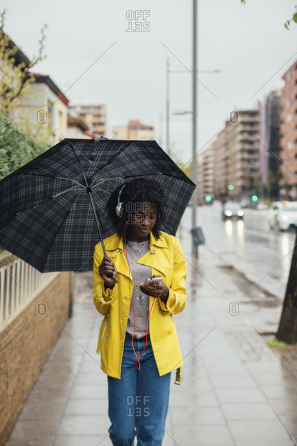 A teenage girl in a hoodie and leggings walks in the city Stock