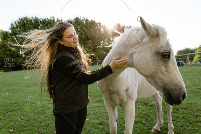Girl petting horse. - Offset Collection