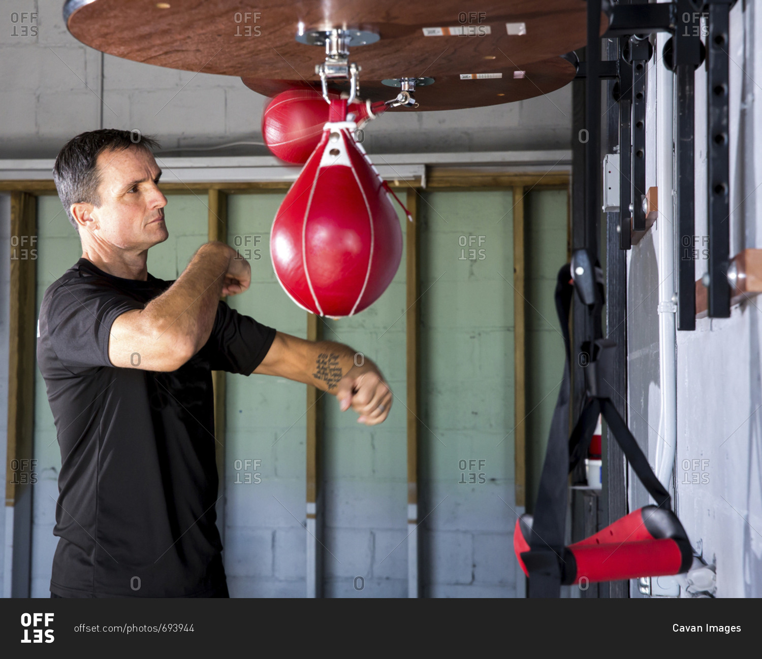 Boxing coach punching speed bag in gym