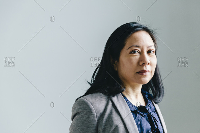 Portrait of serious businesswoman against wall in office