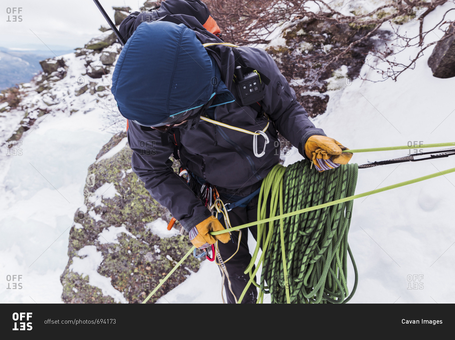 Hiker using ropes while ice climbing at White Mountains during winter