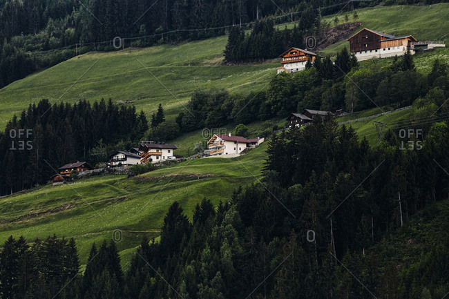 A cluster of traditional houses on the side of a steep hill in Ainet, Austria