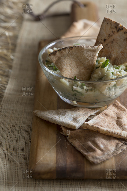 Fresh dip and pita chips on rustic kitchen counter