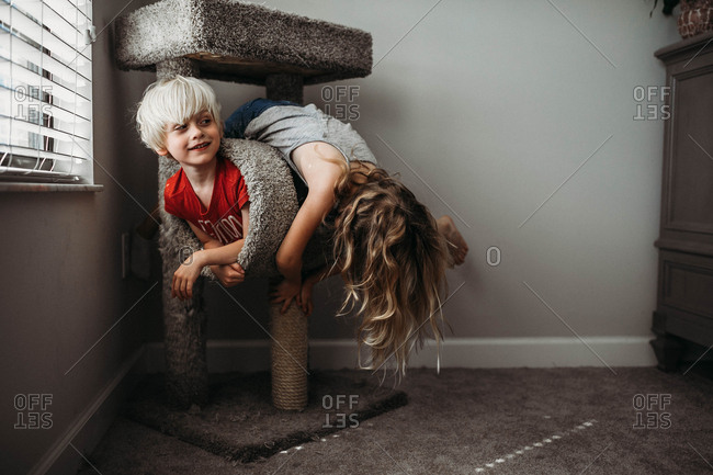 Children play around on a cat scratching post
