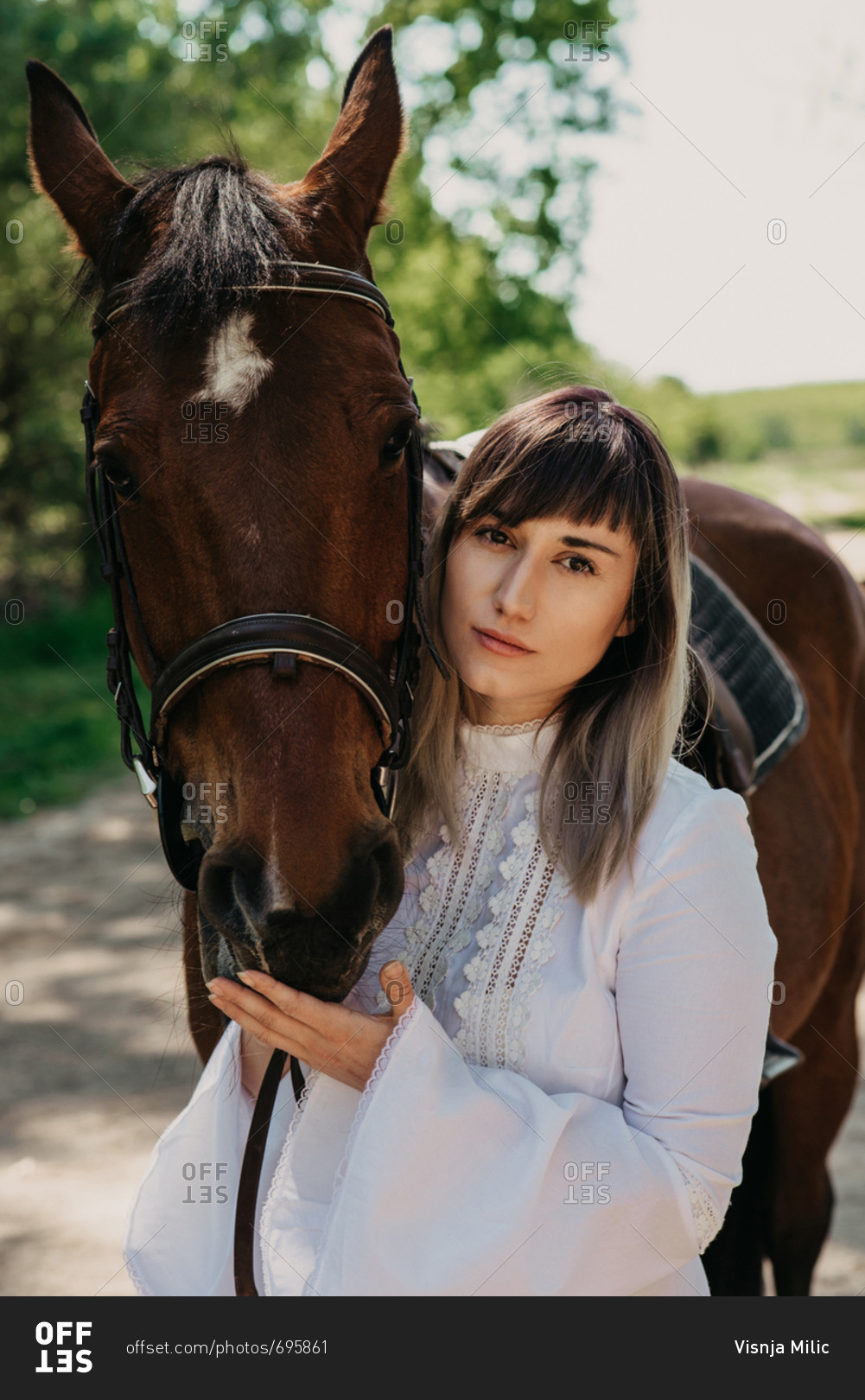 Portrait of woman in white summer dress next to her horse
