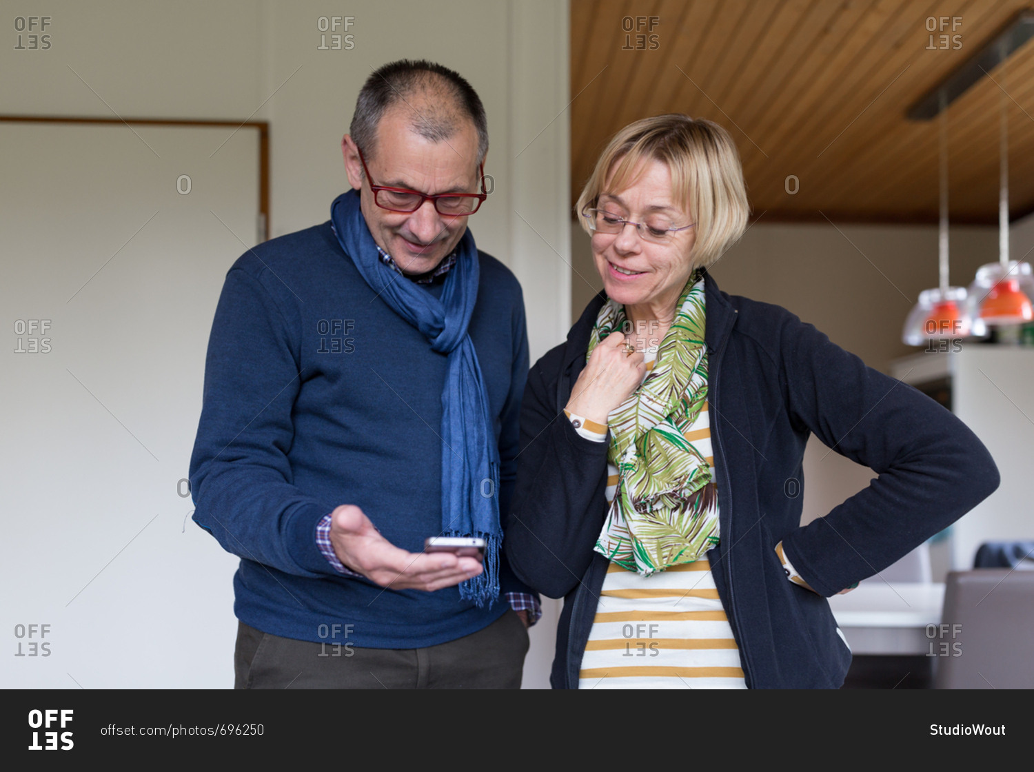 Senior couple in living room looking at mobile device together
